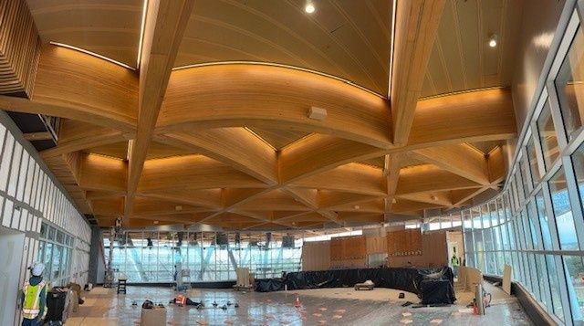 Große Halle mit sichtbarer Tragkonstruktion aus Brettschichtholz